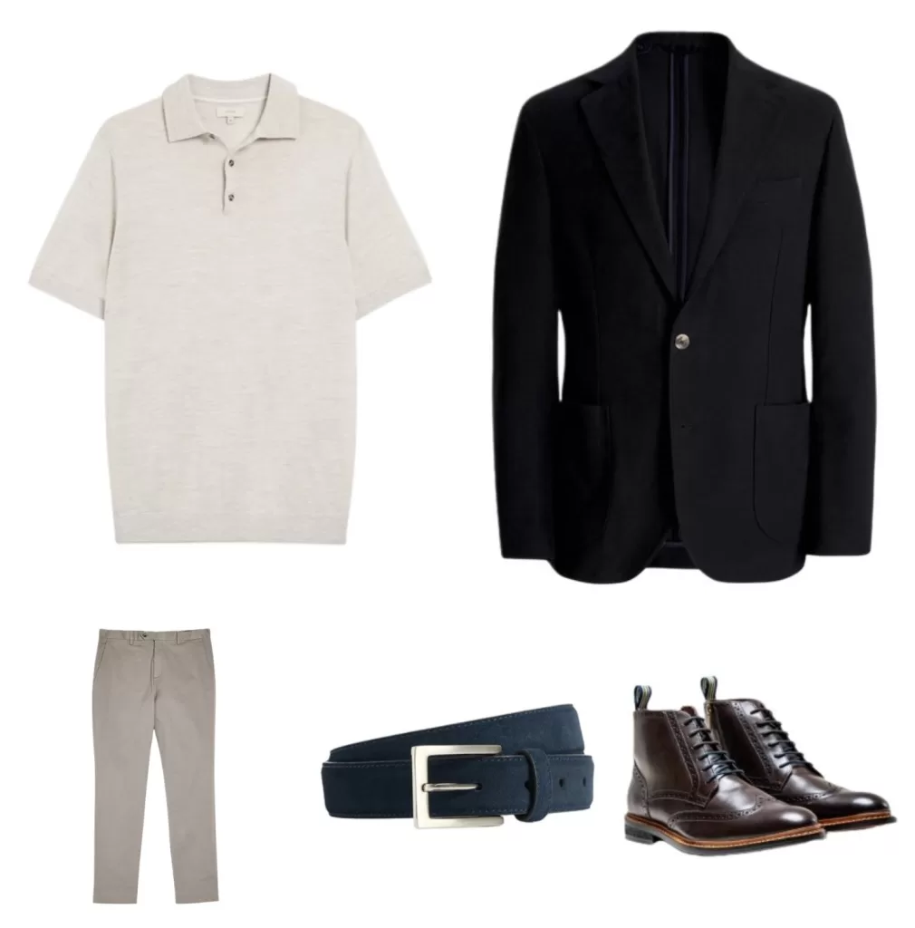 Flat lay of a men's smart casual outfit featuring a light beige knitted polo shirt, navy blazer, stone chinos, navy suede belt and dark brown leather boots.